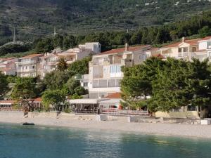 a group of houses on a hill next to the water at Apartments Malina in Tučepi