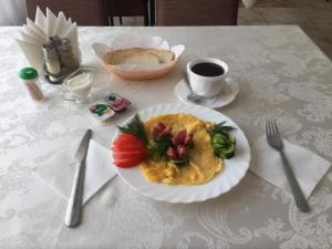 una mesa con un plato de comida y una taza de café en Hotel Sharm, en Khimki
