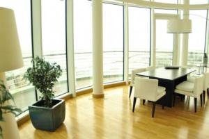 a dining room with a table and chairs and windows at Parque Nacoes Prime Apartments in Lisbon