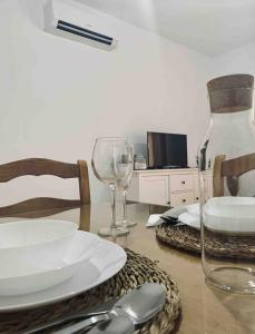 einen Esstisch mit Teller und Weingläsern in der Unterkunft Apartamento Felisa in Arcos de la Frontera