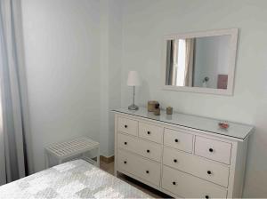 um quarto branco com uma cómoda e um espelho em Apartamento Felisa em Arcos de la Frontera