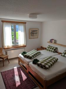 een slaapkamer met 2 aparte bedden en een raam bij Casa Sum Naul in Brigels