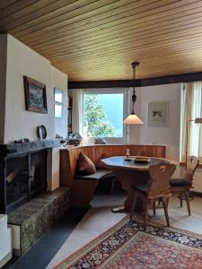 a living room with a table and a fireplace at Casa Sum Naul in Breil/Brigels
