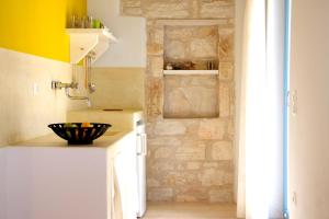 a kitchen with a sink and a brick wall at Nomads House in Logaras