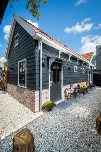 ein schwarzes Haus mit einer Terrasse und einem Tisch in der Unterkunft Luxury Chalets Monnickendam in Monnickendam