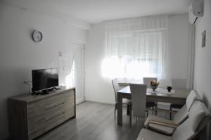 sala de estar con mesa de comedor y TV en Rooms LU&LA, en Velika Gorica