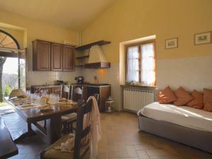 eine Küche und ein Esszimmer mit einem Tisch und einem Bett in der Unterkunft Beautiful Farmhouse with Pool in Arezzo