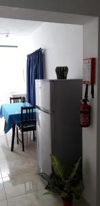 eine Küche mit einem Tisch und einem Kühlschrank im Zimmer in der Unterkunft St Joseph Penthouse in Victoria