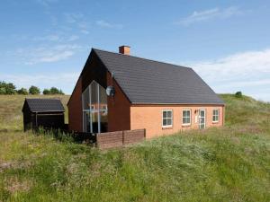 a small house on a hill in a field at Four-Bedroom Holiday home in Hanstholm 3 in Vigsø