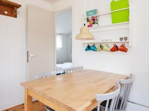 a dining room with a wooden table and chairs at 4 person holiday home in Vejers Strand in Vejers Strand