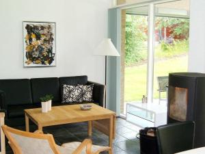 Three-Bedroom Holiday home in Struer 5 في Remmer Strand: غرفة معيشة مع أريكة وطاولة