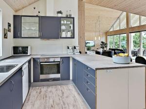 a kitchen with blue cabinets and a counter top at 16 person holiday home in Dronningm lle in Gilleleje