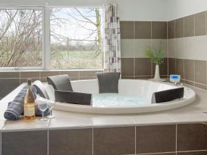 a bath tub with chairs and a bottle of wine at 18 person holiday home in Hasselberg in Kappeln