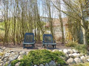 two chairs sitting on a patio in a garden at Three-Bedroom Holiday home in Struer 5 in Remmer Strand