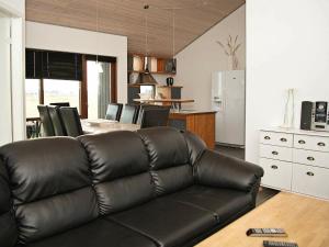 Thorsmindeにある8 person holiday home in Ulfborgのリビングルーム(革張りのソファ付)、キッチン