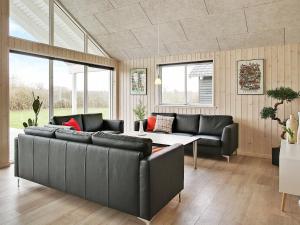 a living room with couches and a table and windows at 18 person holiday home in Hasselberg in Kappeln