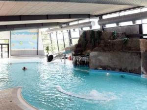 a pool with a slide in a water park at 14 person holiday home in Bl vand in Ho