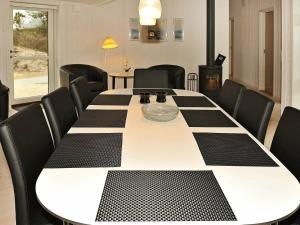 a black and white table with black chairs around it at 8 person holiday home in Henne in Henne Strand