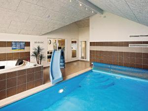 a swimming pool with a slide in a building at 16 person holiday home in Hasselberg in Kappeln