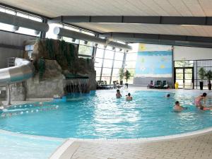 a group of people in a swimming pool at 14 person holiday home in Bl vand in Ho