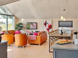 ボーゲンセにあるFive-Bedroom Holiday home in Bogenseのリビングルーム(オレンジの椅子、テーブル付)