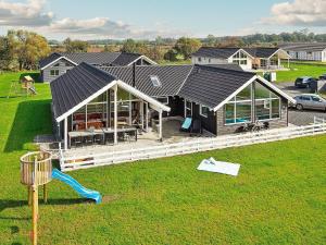 - une vue aérienne sur une maison avec une aire de jeux dans l'établissement Five-Bedroom Holiday home in Bogense, à Bogense