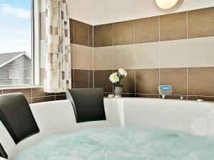 La salle de bains est pourvue d'une baignoire avec 2 chaises. dans l'établissement 20 person holiday home in Hasselberg, à Kappeln