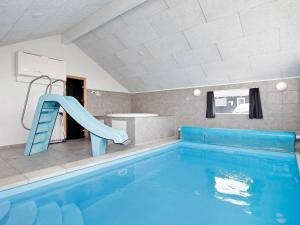ボーゲンセにあるFive-Bedroom Holiday home in Bogenseの家屋内の青い滑り台付きスイミングプール