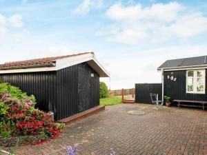 a backyard with a black building and a bench at 4 person holiday home in Struer in Struer