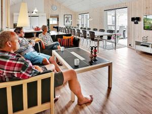 22 person holiday home in Bogense في بوجنسي: مجموعة من الناس يجلسون على أريكة في غرفة المعيشة