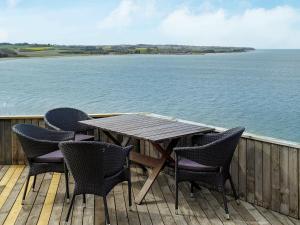 a wooden table and chairs on a deck next to the water at 4 person holiday home in Struer in Struer