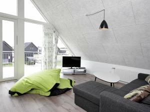 a living room with a couch and a tv at 8 person holiday home in R m in Rømø Kirkeby