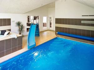 une piscine intérieure avec toboggan dans une maison dans l'établissement 16 person holiday home in Hasselberg, à Kappeln