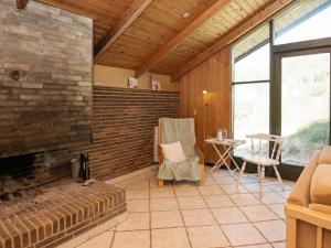 ロンストラップにある4 person holiday home in L kkenのリビングルーム(レンガ造りの暖炉、椅子付)