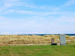 un banco de madera sentado en un campo cerca del océano en 6 person holiday home in Hadsund, en Øster Hurup