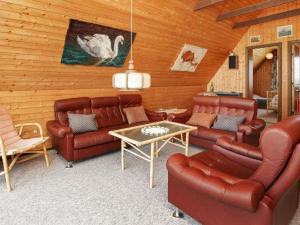 a living room with leather couches and a table at 5 person holiday home in Harbo re in Harboør