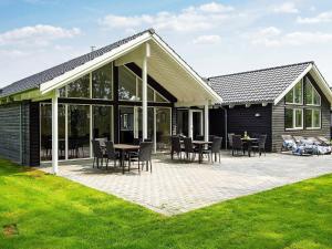 une maison avec un patio avec des tables et des chaises dans l'établissement 16 person holiday home in Hasselberg, à Kappeln