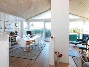 6 person holiday home in Hadsund في Øster Hurup: غرفة طعام مع طاولة وكراسي بيضاء