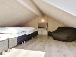 Cette chambre mansardée comprend 2 lits et une télévision. dans l'établissement 16 person holiday home in Hasselberg, à Kappeln 17 autres photos