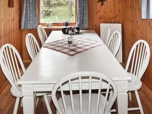 a white dining room table with white chairs at Holiday home FINNÅS in Vordnes