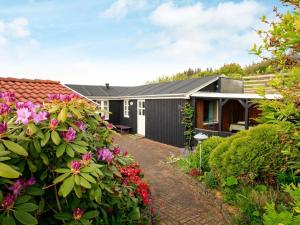 a house with a garden with flowers in front of it at 4 person holiday home in Struer in Struer
