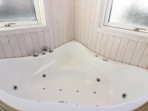 baño con bañera blanca y ventana en 6 person holiday home in Hadsund, en Øster Hurup