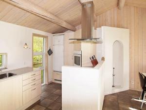 a kitchen with white cabinets and a stove top oven at 6 person holiday home in Tarm in Tarm