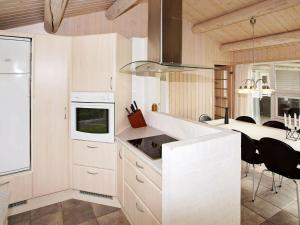 a kitchen with white cabinets and a dining room at 6 person holiday home in Tarm in Tarm