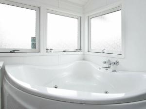 een badkamer met een wit bad en 2 ramen bij 6 person holiday home in L kken in Løkken
