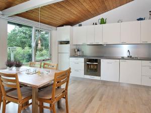 SaltumにあるHoliday Home Tippenの白いキャビネットと木製テーブル付きのキッチン