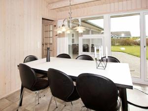 a dining room with a white table and black chairs at 6 person holiday home in Tarm in Tarm