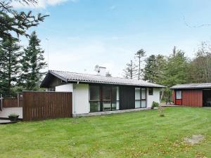 a white house with a fence and a yard at 6 person holiday home in Saltum-By Traum in Saltum