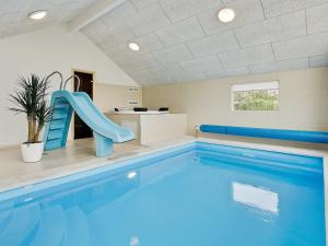 a large swimming pool with a slide in a building at 14 person holiday home in Faaborg in Bøjden