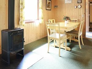 een eetkamer met een tafel en een fornuis bij Two-Bedroom Holiday home in Ulfborg 4 in Sønder Nissum